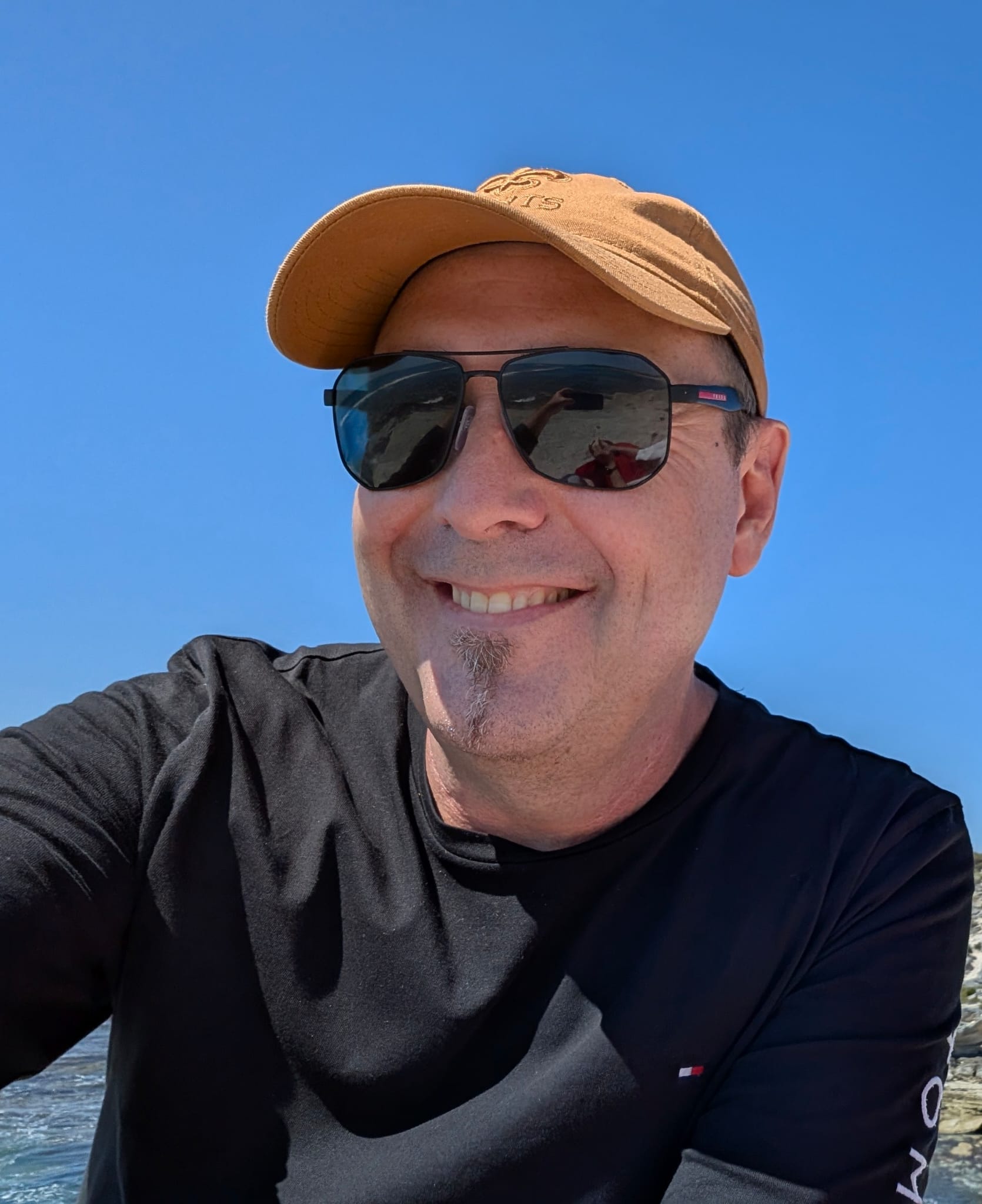 Paul Seymour - Beach selfie with sunglasses and cap, casual and approachable